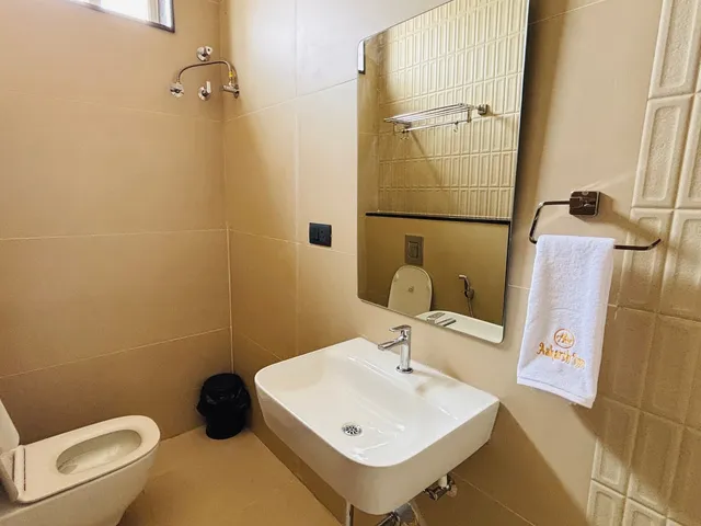 Bathroom with beige textured tiles, glass shower cubicle and wall-hung basin