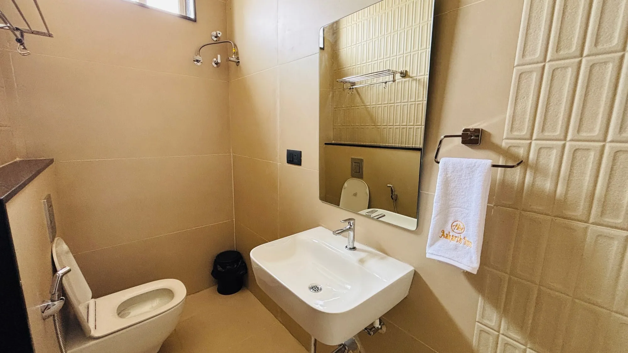 Bathroom in beige textured tile with glass shower
