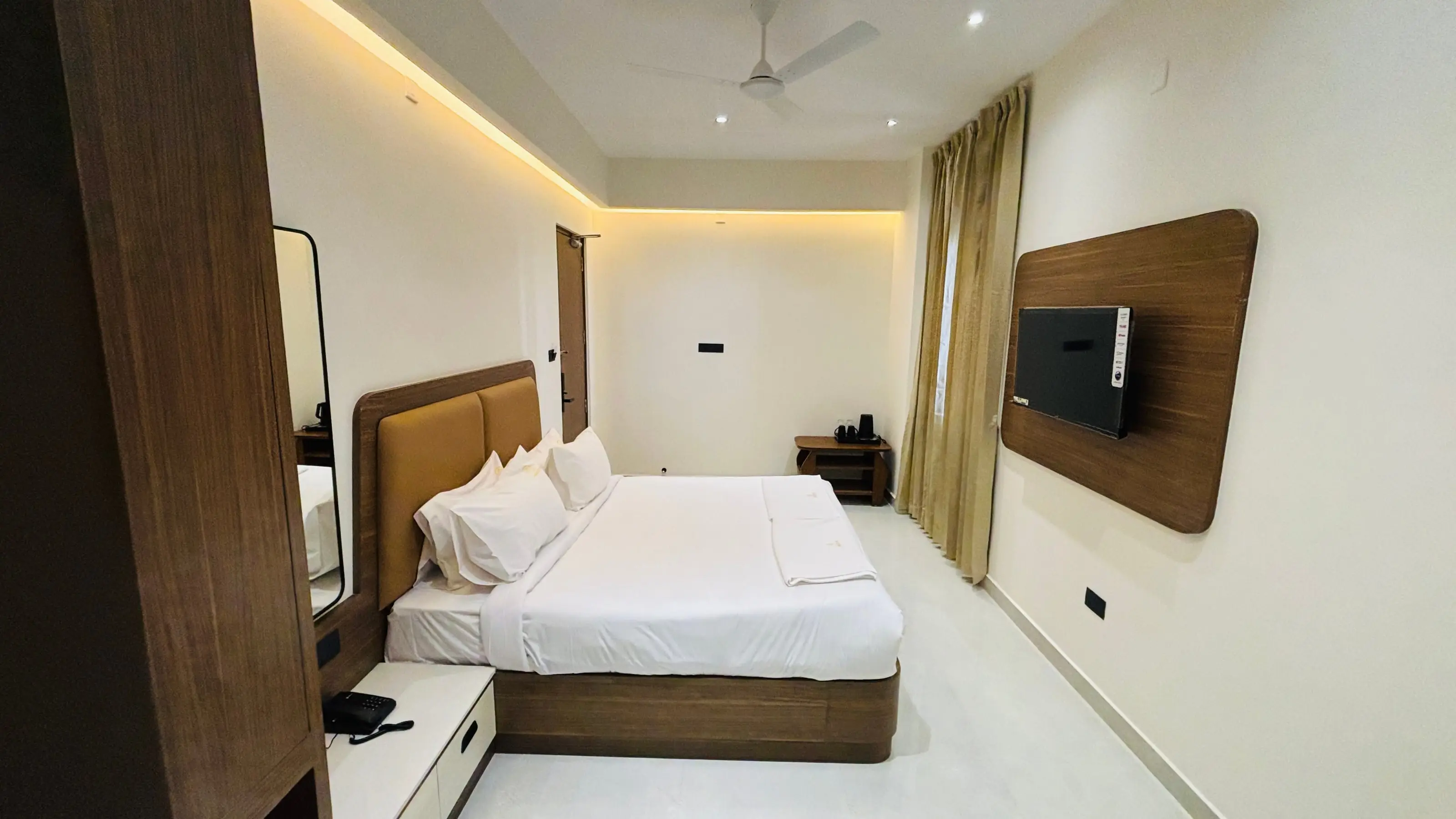 Superior King Room at Aakarsh Inn with the bed made and the curtains open