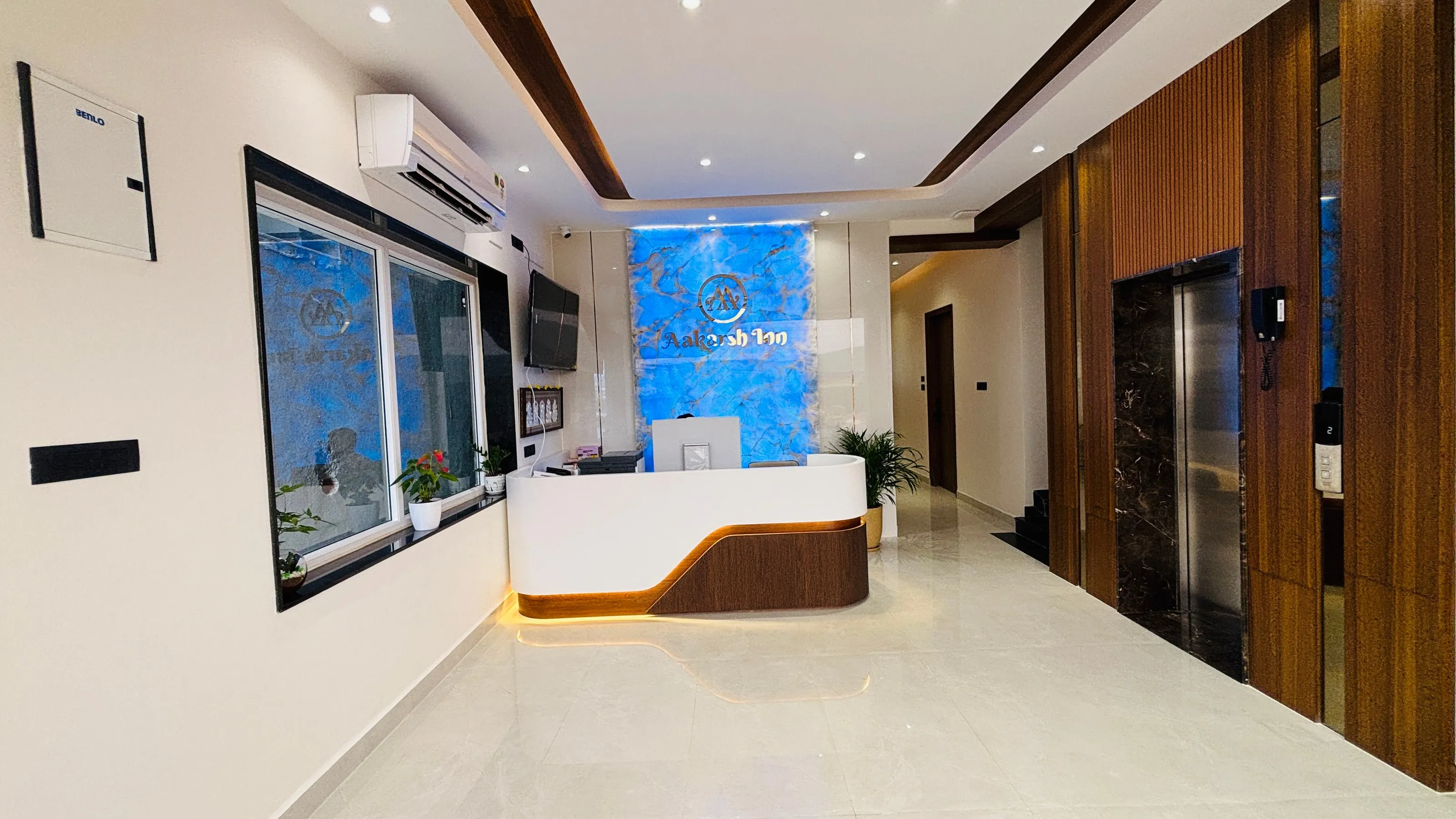 Reception desk at Aakarsh Inn with walnut panelling